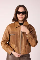 Campera corta de cuero sintético negra con detalles en gamuza color borgoña en la parte superior del pecho y bolsillos con cierre.