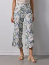Pantalón crop de lino estampado con hojas en tonos verdes y azules. Tiene pretina trasera elastizada y bolsillos delanteros.