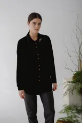 Camisa beige de terciopelo con botones, corte recto y cuello clásico.