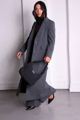 Bolso negro de nylon con textura sutil y manija fruncida.