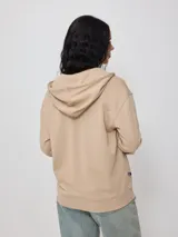 Canguro con cierre y bordado delantero, color beige.