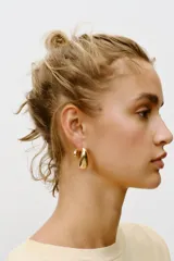 Aros metálicos dorados con forma de gota.