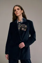 Blazer azul con finas rayas verticales, de corte cruzado con un botón, hombreras y bolsillos con solapa.