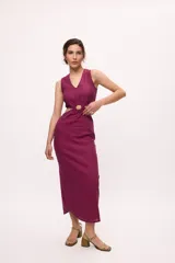 Vestido midi color fucsia, con corte a la cintura y falda tubo con tajo lateral. Presenta un top sin mangas con detalle cut-out en la cintura.