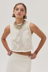 Top tejido de punto calado color crudo con diseño de flores, escote redondo y lurex en el escote.