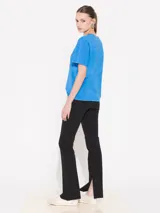 Pantalón negro tipo flare con cierre lateral y elástico en la cintura, cuenta con tajo en la costura interna inferior.
