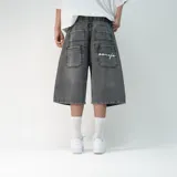 Bermuda de jean negra, corte holgado, con bolsillos traseros y detalle de bordado en uno de ellos.