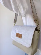 Bandolera color crudo con solapa de gamuza y cuerpo de cuero sintético texturizado. Tiene correa corta de cuero con tientos y forro de tela con bolsillo interno.
