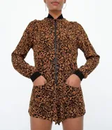 Mono corto con estampado animal print, cuello mao, cierre frontal con cremallera y mangas largas.