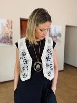 Chaleco color crema con bordados florales en negro y ribete de crochet.