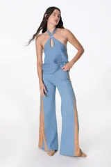 Pantalón ancho de jean celeste con paneles laterales en tela color camel con estampado sutil.