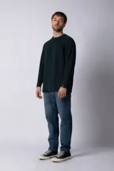 Sweater marrón de punto con cuello redondo y mangas largas raglán. Tejido grueso con textura acanalada. Corte holgado.