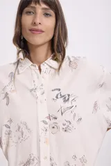 Camisa beige con estampado abstracto en tonos grises, azules y marrones. Corte oversize, mangas cortas y cuello clásico.