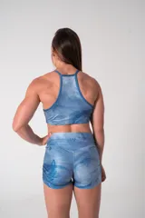 Top deportivo celeste con estampado de olas, breteles finos y logo de la marca en el pecho.