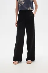 Pantalón de lino negro, de tiro alto y corte recto ancho, con bolsillos laterales.
