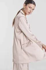 Blazer blanco de corte recto, con solapas y bolsillos laterales.