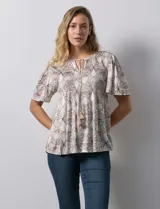 Blusa de tejido elastizado con estampado geométrico en tonos beige y blanco. Tiene cuello redondo con escote en V y lazo de ajuste, y mangas cortas amplias. Marca Cupio.