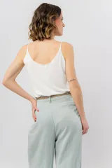 Musculosa lila de breteles finos con escote en V en el frente y espalda en U, confeccionada en tejido fluido con leve textura satinada.