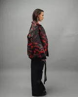 Campera reversible negra con estampado abstracto en rojo y blanco, de corte amplio y cuello camisero.