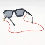 Correa para lentes color rojo, hecha de cristal, con cierre dorado y diseño adaptable para mascarillas.