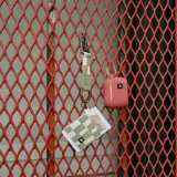 Billetera elástica Thread con diseño a cuadros en tonos verde y blanco. Cuenta con un llavero y espacio para tarjetas.