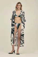 Vestido camisero largo de lino y viscosa con estampado abstracto en blanco y negro. Tiene corte holgado, cuello camisero, mangas cortas, cierre frontal con botones de madera y bolsillos laterales.