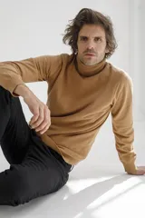 Sweater color marrón claro de punto con cuello alto.