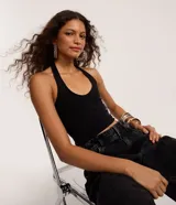 Top halter negro, ajustado al cuerpo, con escote pronunciado en V y espalda descubierta.