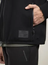 Campera negra con capucha, cierre frontal y bolsillos laterales con cierre.