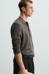 Polo azul marino de punto ligero tejido en hilatura con mezcla de seda y algodón. Cuello solapa con cierre frontal de botonadura, manga larga y acabados en rib.