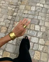 Brazalete rígido plateado con textura irregular.