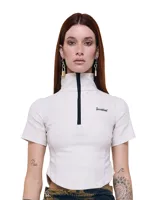 Top corto color crudo, de gabardina elastizada, con cuello alto, cierre frontal y mangas cortas.