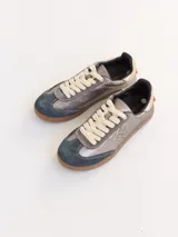 Championes urbanos de cuero color plateado con puntera de gamuza azul y cordones blancos.
