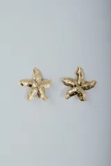 Aros colgantes con forma de estrella de mar dorada con textura irregular.
