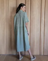 Vestido túnica celeste de lino con rayas verticales blancas, corte recto, cuello camisero y mangas cortas.
