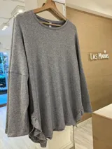 Buzo gris de lanilla con lurex, corte holgado y volados en los laterales inferiores.