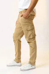 Pantalón cargo color beige, de corte ajustado, con bolsillos laterales con fuelle y cierre de botón a presión.