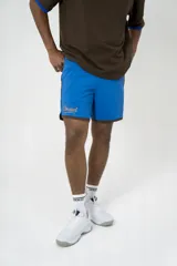 Short deportivo azul con ribete marrón y logo bordado en el muslo.