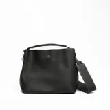 Cartera tipo tote bag color negro, con textura símil cuero, doble asa de mano y correa bandolera desmontable.
