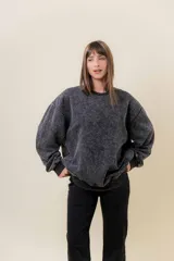 Sweater de calce oversize, color gris oscuro con efecto lavado vintage, cuello redondo y puños acanalados.