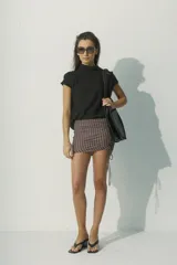 Blusa negra de lino con cuello alto y mangas cortas con detalle de calado en los hombros.