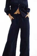 Pantalón amplio de lino color azul marino, con cintura elástica ajustable con cordón y bolsillos laterales.