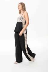 Pantalón sastrero de lino italiano color negro con guarda de broderie crudo desde la cintura hasta el bajo.