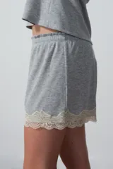 Conjunto de pijama gris compuesto por un top de breteles finos con puntilla en el escote y un short con puntilla en el ruedo.