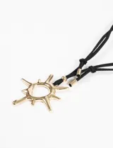 Collar con cordón negro ajustable y dije dorado con forma de sol.