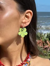 Aros colgantes con forma de flor pintada a mano en tonos verde y amarillo, con argolla de acero quirúrgico. Cada pieza es única debido a su elaboración artesanal.
