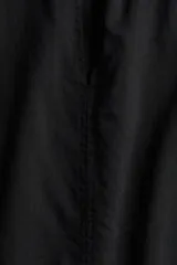 Blusa negra de corte holgado en tejido liviano de algodón y viscosa. Modelo de manga japonesa con escote en V y cuello mao con frunces adelante y atrás. Bajo redondeado.