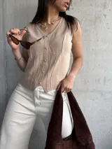 Musculosa beige con escote en V y botones al frente.