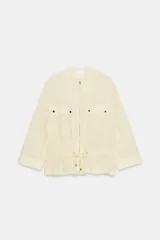 Blazer color crema de cuello redondo y manga larga. Cuenta con bolsillos de plastrón con solapa y botones, cintura ajustable con cordones y cierre frontal con cremallera metálica.
