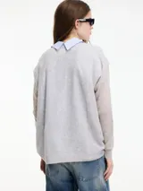 Sweater tejido color lila, escote en V, de tejido liviano.